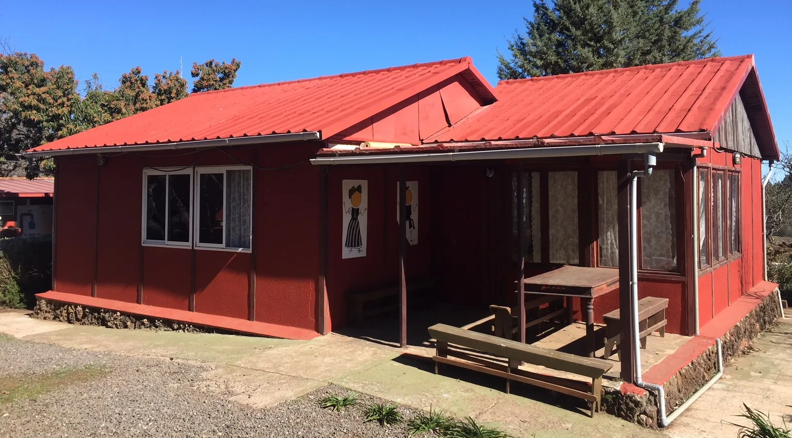 Casa 1 del campamento, de color rojo, con porche