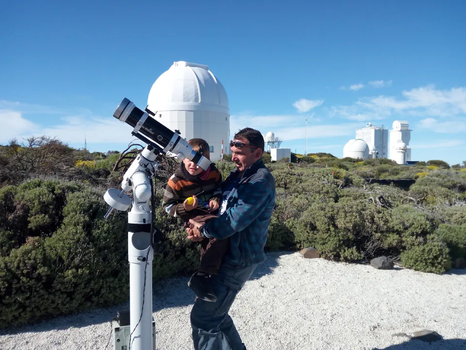 Quim con un niño observando por el telescopio solar junto a los observatorios del Teide