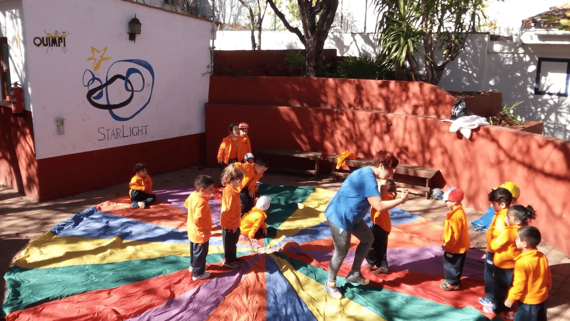 Niños jugando con el paracaídas de colores